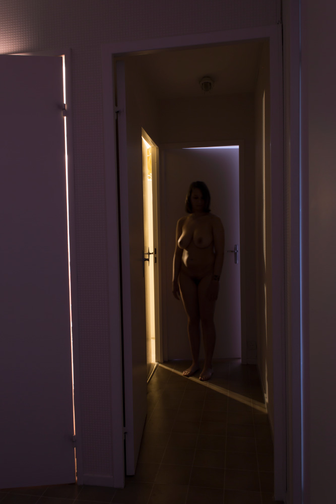 Photographie du couloir en pose longue, la lumière marque le modèle nu et le décor